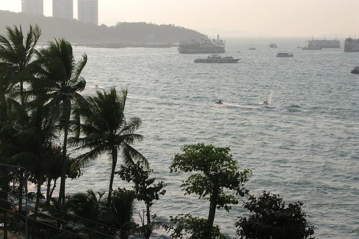 อ่าวพัทยา จังหวัดชลบุรี ประเทศไทย มีต้นปาล์มและแนวอาคารริมชายหาด